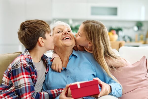 Granddaughter,And,Grandson,Surprises,Her,Grandmother,With,Present,On,Mother's